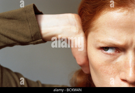 Junge Frau für Ohr mit Hand, Nahaufnahme Stockfoto