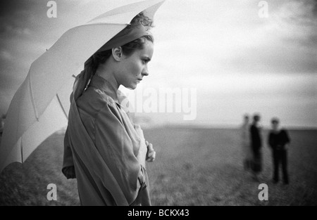 Frau am Strand unter Dach, Gruppe in Ferne, b&w Stockfoto