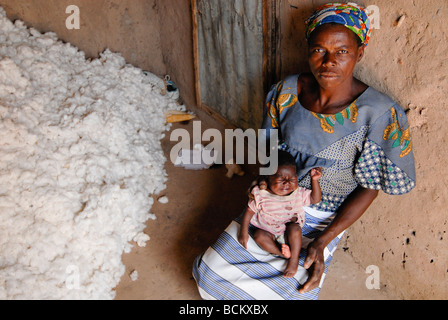 Westafrika Burkina Faso, Fairtrade und Bio-Baumwoll-Projekt, Ehefrau von Baumwolle Bauer mit Kind bei Baumwolle speichern in ihrer Hütte Stockfoto