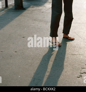 Frauenbeine stehen auf Straße Stockfoto