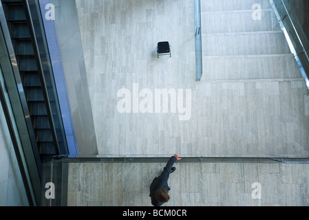 Architektonische Schuss, Mann auf Mezzanine, hält Schiene, Blick vom direkt über Stockfoto