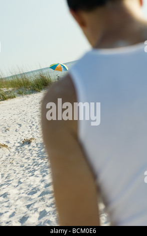 Mann zu Fuß am Strand, beschnitten, schräge Ansicht Stockfoto