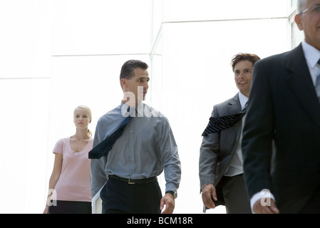 Business-Leute zu Fuß in Richtung Kamera, chatten Stockfoto