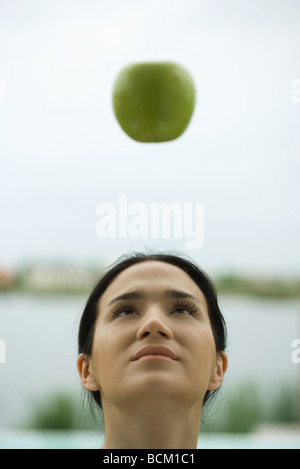 Frau, die bei Apple, die schwebend in der Luft, Vorderansicht Stockfoto
