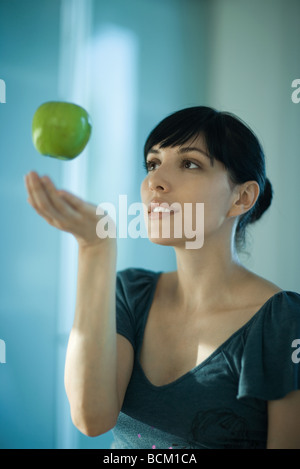 Apple, die schwebend in der Luft über zarte Frauenhand Stockfoto