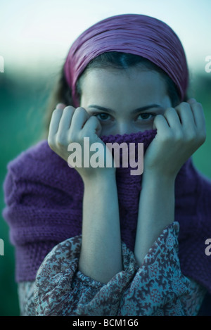 Frau hochziehen Pullover über Mund, Blick in die Kamera, Nahaufnahme Stockfoto