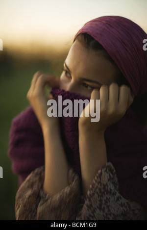 Frau hochziehen Pullover über Mund, wegsehen, Nahaufnahme Stockfoto