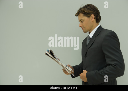 Geschäftsmann lesen Zeitung, Seitenansicht Stockfoto
