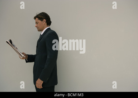 Geschäftsmann, stehen, lesen Zeitung, Seitenansicht Stockfoto