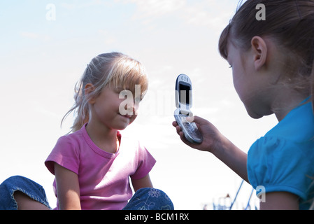 Mädchen unter Bild von Freund mit Handy, niedrigen Winkel Ansicht Stockfoto