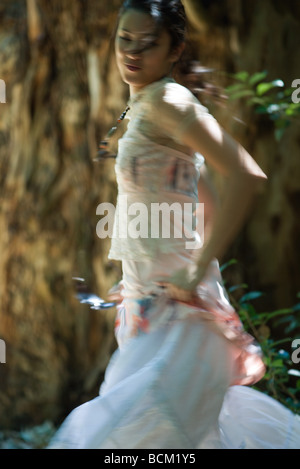 Junge Frau, die Spinnen im Freien, Bewegungsunschärfe Stockfoto