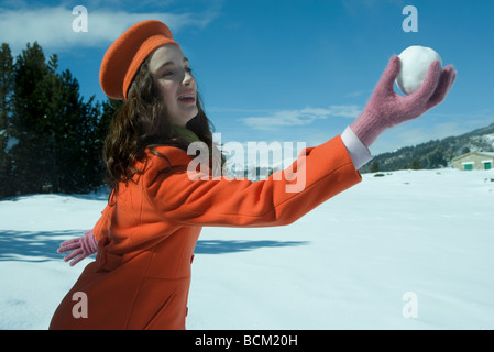 Teenager-Mädchen hält Schneeball, Seitenansicht Stockfoto