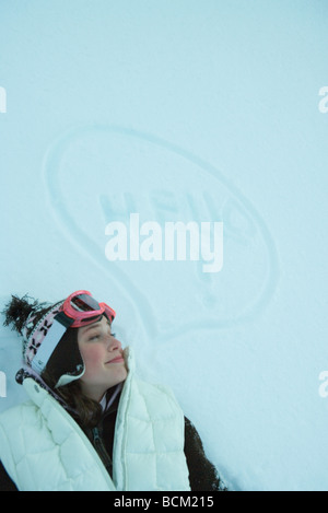 Teenager-Mädchen auf Schnee liegen neben dachte, Blase und das Wort "Hello" Stockfoto