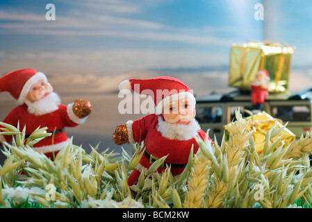Santa Claus Figuren liefern Geschenke im Weizenfeld Stockfoto