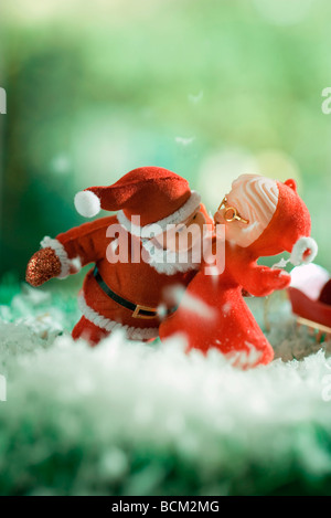 Santa Claus Figur lehnt in Frau zu küssen Stockfoto