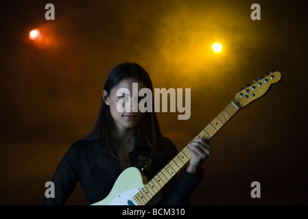 Weiblich e-Gitarre zu spielen, im Nachtclub, Blick in die Kamera Stockfoto