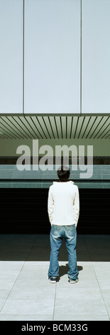 Junge männliche Rückansicht stehen im Freien, nachschlagen, Stockfoto