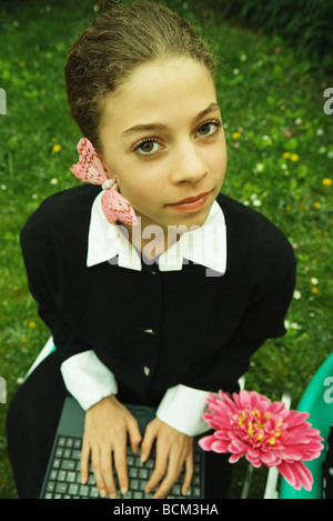 Teenager-Mädchen mit Schmetterling auf Wange, lächelnd in die Kamera, Eingabe über Tastatur, Porträt Stockfoto