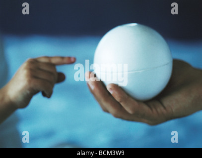 Erwachsenen Hand mit Ball, Kind erreicht mit Finger zu berühren Stockfoto