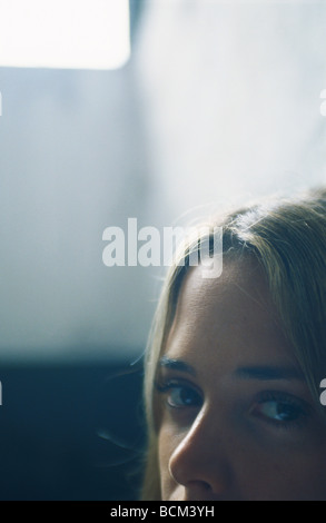 Junge Frau, Blick in die Kamera, Hintergrundbeleuchtung, beschnitten Ansicht Stockfoto