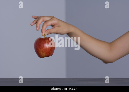 Frau hält Apple durch den Stamm abgeschnitten Blick auf arm Stockfoto