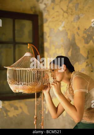 Frau, innen leer Vogelkäfig, Seitenansicht Stockfoto