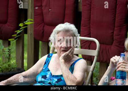 Nachdenkliche Momente als Mutter und Großmutter sprechen am Pool. Stockfoto