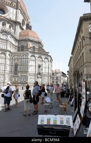 Künstler stellen ihre Werke an Touristen außerhalb der Duomo und Campanile-Turm in Florenz, Italien Stockfoto