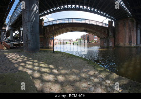 Blick durch die viktorianischen Eisenbahn-Viadukte in Richtung der Krämerbrücke im Castlefield Bassin Manchester Stockfoto