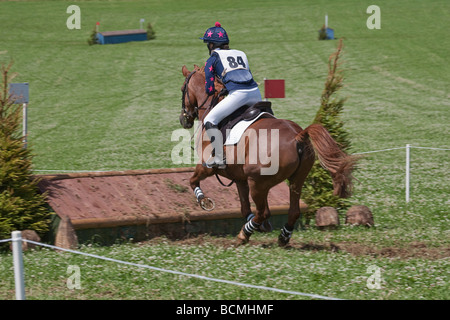 Teenager-Mädchen auf braunen Pony/Pferd springen Zaun im Langlauf-Event. Stockfoto