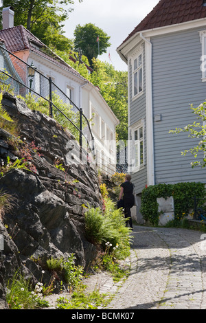 Weiblich, zu Fuß in einer Gasse auf eine alte Stadt und Holzhaus Stockfoto