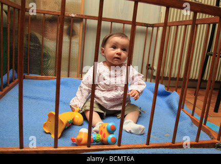 6 Monate altes Baby Mädchen im Laufstall Stockfoto