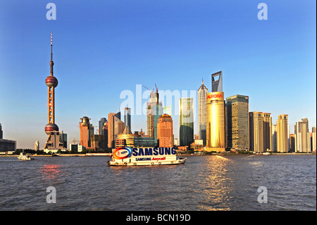 Blick auf den Sonnenuntergang von Skycripers in Pudong-Area mit Werbe-Boot im Fluss Pudong, Shanghai, China Stockfoto