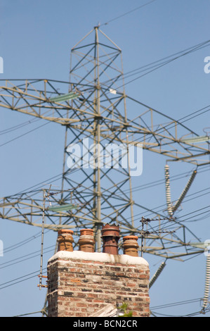 Strom-Pylon und Haus-Schornstein Stockfoto