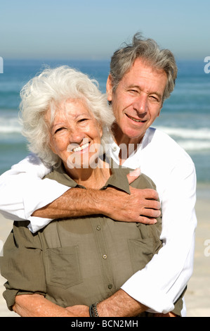 Porträt von älteres paar umarmt einander am Strand, Tabellenansicht Stockfoto