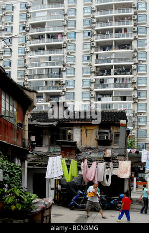 Mann spielt mit Kindern im traditionellen Wohnhäuser neben modernen Mehrfamilienhaus, Shanghai, China Stockfoto