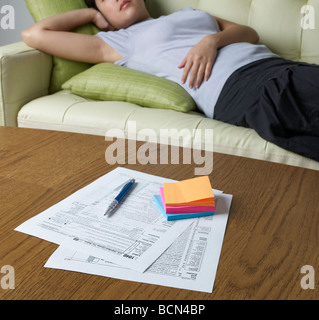 Steuerformulare auf dem Tisch liegende Frau im Hintergrund Stockfoto