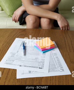 Frau auf Sofa und Steuerformulare Stockfoto