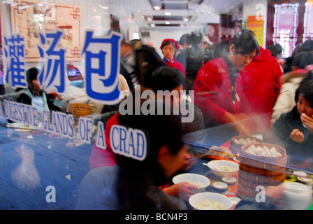 Menschen, die genießen gedämpften Brötchen in ein gedämpftes Brötchen-Spezialitäten-Restaurant, Shanghai, China Stockfoto