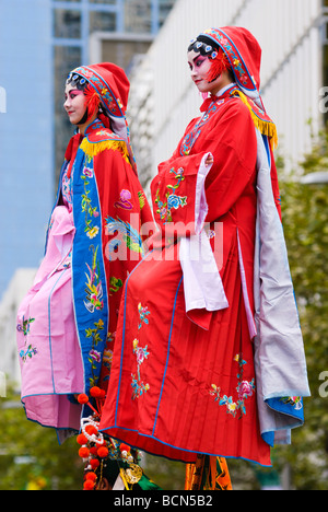 Zwei junge chinesische Frauen in bunten Trachten, während eine Chinesische Neujahrsparade. Stockfoto