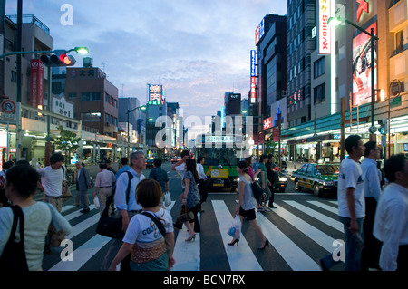 Man überquert einen Zebrastreifen in Shibuya Geschäftsviertel Tokyo Japan Stockfoto