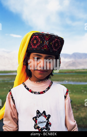 Lächelnd ethnischen Tajik Mädchen tragen regelmäßige Kleidung und haben dennoch ihren traditionellen Kopfbedeckung auf Taxkorgan Tajik autonome Stockfoto