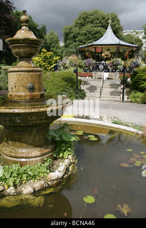 Stadt von Truro, England. Verzierten Brunnen in Truro Victoria Gardens mit dem viktorianischen Musikpavillon im Hintergrund. Stockfoto