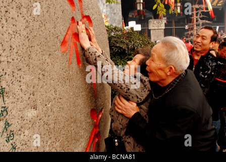 Ältere chinesisches Ehepaar berührt das Schnitzen von Xishenfang Gedenktafel für viel Glück am ersten Tag des chinesischen neuen Jahres in Stockfoto