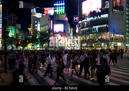 Fußgänger überqueren Sie die Straße im Geschäftsviertel von Shibuya Tokio Japan Stockfoto