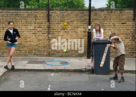 Kinder, die Cricket spielen in Straßenjungen-Mädchen. Brunswick Street Walthamstow London E17, mit dem Mülleimer im Wicket. 2009 2000s England HOMER SYKES Stockfoto