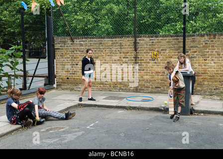 Kinder spielen Cricket in der Straße Junge und Mädchen. Brunswick Street Walthamstow London E17 mit dem Mülleimer im Wicket. 2009 HOMER SYKES Stockfoto