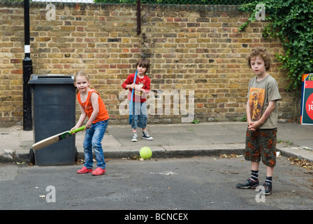 Kinder spielen Cricket in der Straße Junge und Mädchen. Brunswick Street Walthamstow London E17 mit dem Mülleimer im Wicket. 2009 HOMER SYKES Stockfoto