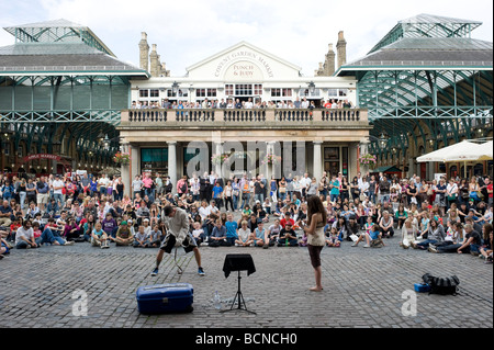 Eine Straße Entertainer führt zu einer großen Schar von Touristen in Covent Garden in London. Stockfoto