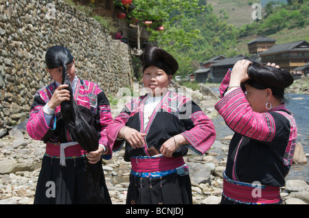 Drei lange Haare Yao Frauen Vorbereitung Haar neben Fluss Huangluo Dorf Guangxi China Stockfoto